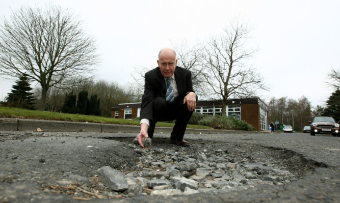 Mr Wilson at the pothole.