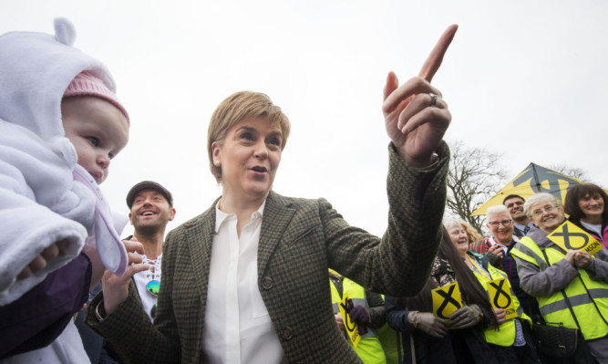 Nicola Sturgeon meets three-month-old Emily Kidd during an election campaign visit to Glencassles Community Development Project in Wishaw.