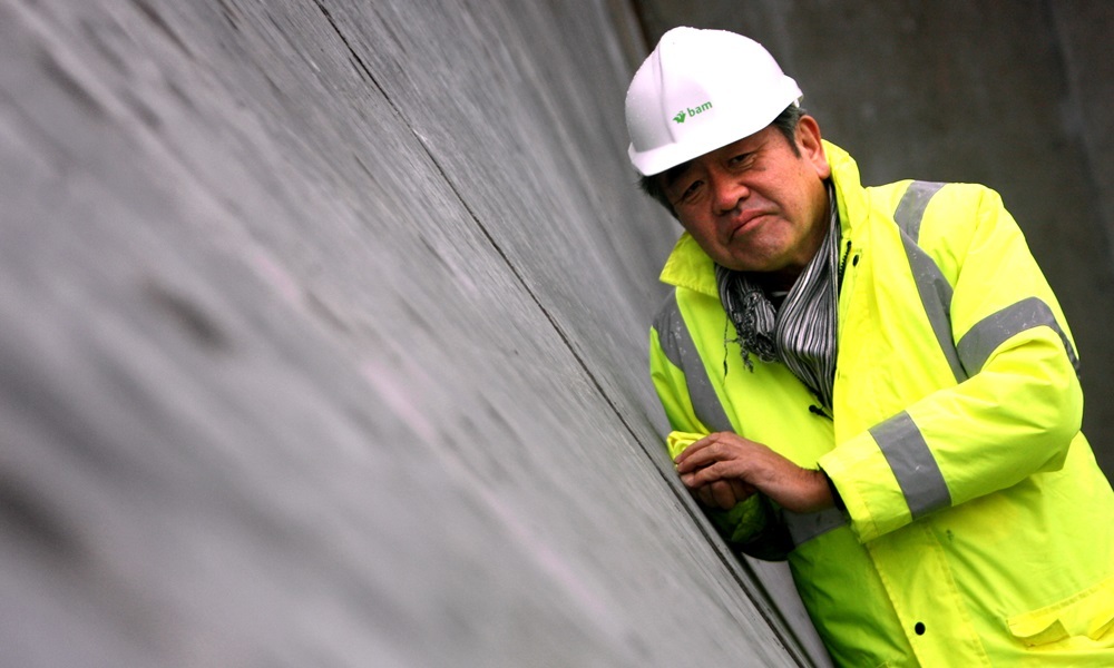 Kris Miller, Courier, 01/04/16. Picture today on V&A Dundee site visit where Kengo Kuma visited to see how work is progressing on his design. Pic shows the architect looking at one of the curved walls taking shape.