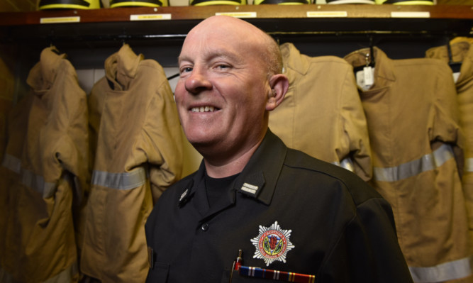 Mearns fire crew manager Graeme Godsman and, below, with fellow crew members who presented him with gifts on his retirement.