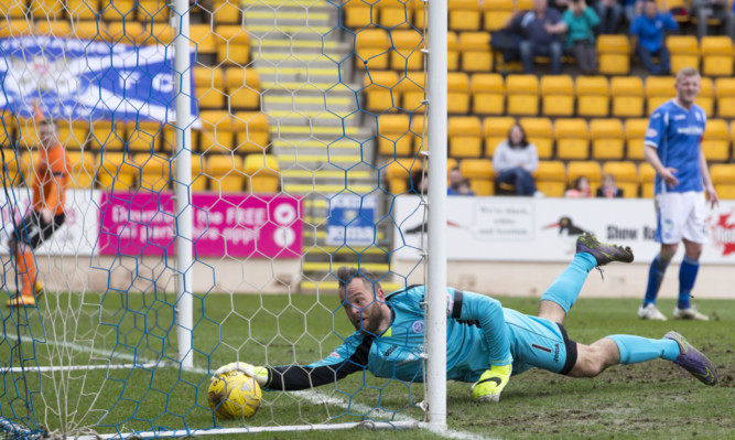 Alan Mannus tries in vain to keep Ryan Dow's shot out.