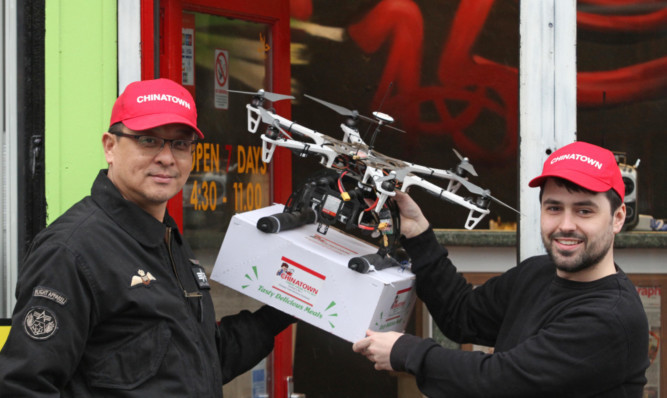 Steven Chow, left, and Greg Suttie with the drone outside the Chinatown takeaway.