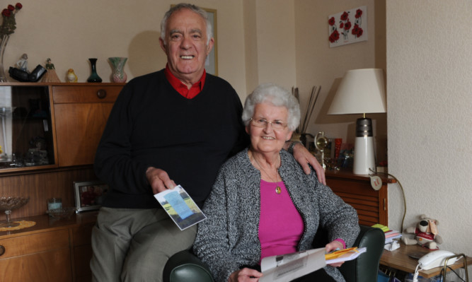 Ernie and Eva Orrock at home in Carnoustie with pictures and information about the grave of Pte George Turnbull Orrock from the War Graves Commission.
