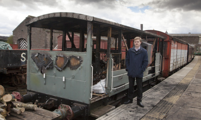 Events manager Andrew Pegg beside the fire-ravaged brake van.