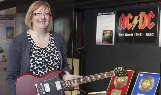 Senior museum assistant Rachel Jackson with the signed Gibson SG electric guitar.