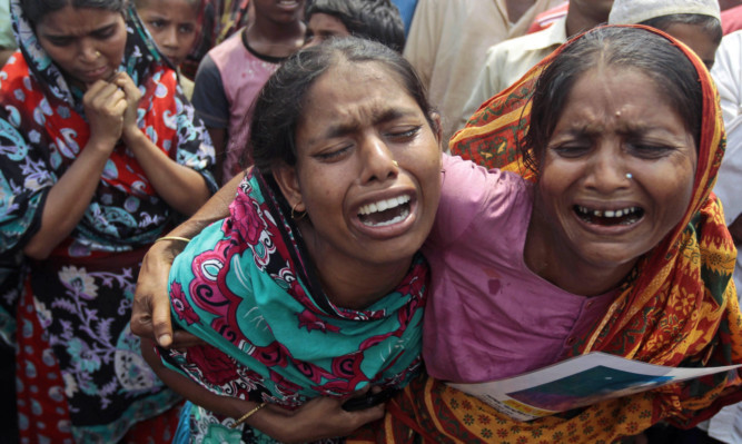 Bangladeshi women cry for their missing relatives during prayers in Savar.