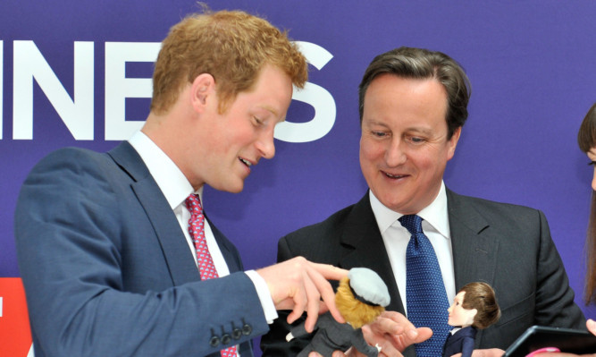 Prince Harry and David Cameron are presented with dolls of themselves created by UK firm Makies.