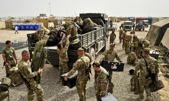 Troops from 1 Scots load gear onto a truck ready to depart camp Toombstone, Afghanistan, where they are leaving theatre after their tour of duty in the Brigade Advisory Group to fly back to the UK. PRESS ASSOCIATION Photo. Picture date: Sunday April, 7, 2013. See PA story DEFENCE Afghanistan Scots. Photo credit should read: Ben Birchall/PA Wire
