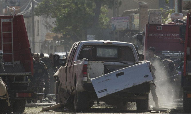 Afghan and US soldiers arrive at the scene of the suicide car bombing.