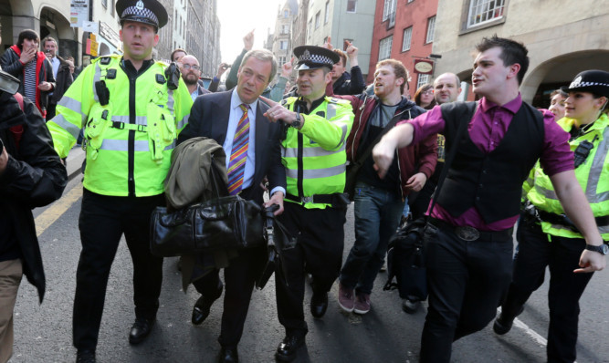 Mr Farage being escorted away by police on Thursday evening.