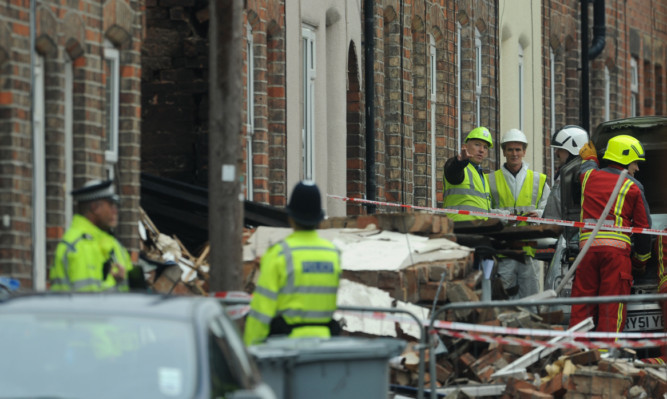 Emergency services out the remains of a house in Wright Street.