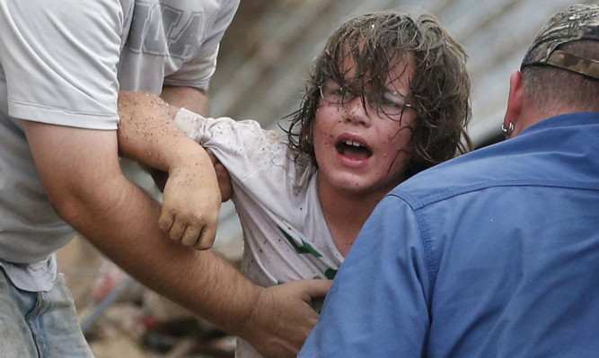 A child calls to his father after being pulled from the rubble of the Tower Plaza Elementary School.