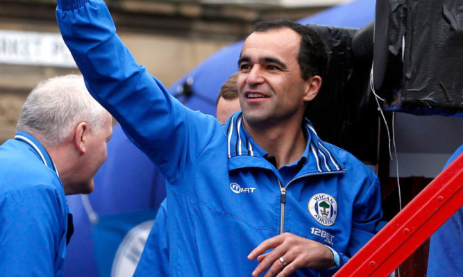 Roberto Martinez salutes the crowds on the streets of Wigan.