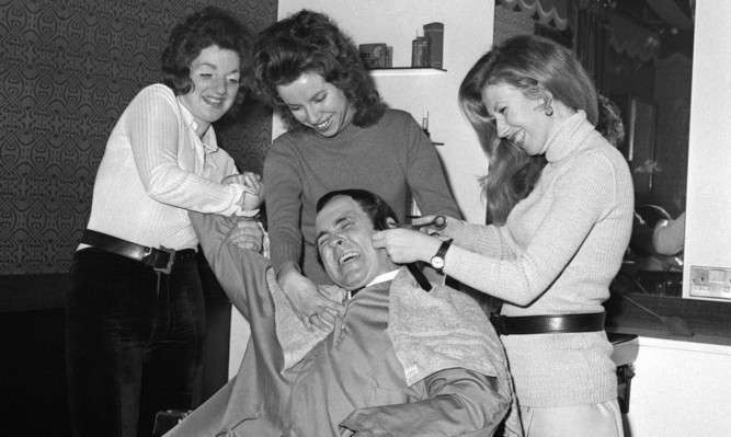 Wrestler Mick Mcmanus receiving a haircut  at Fagin's hairdressing salon in London in 1970.
