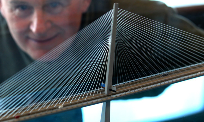 Raemond Hay, a worker on the original Forth Road Bridge, views a model of the new crossing.