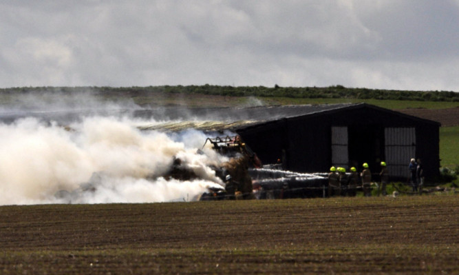 Smoke blows across the fields at Balstout Farm near Montrose after a shed with bales of hay caught fire.