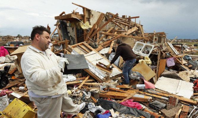 Jon Johnson, left, with brother Matt, looks at the remains of his home after the tornado ripped it apart.