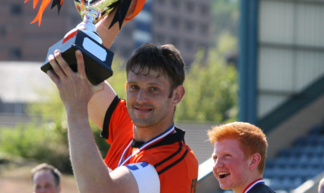 Winning team captain Steven Fotheringham holds up the trophy.