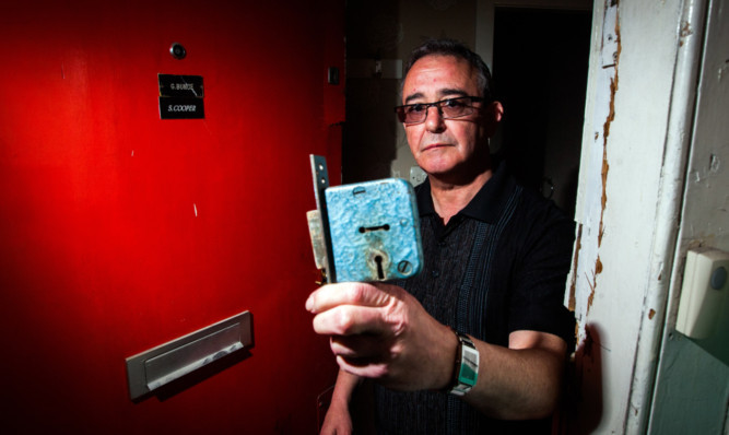 Gordon Bunce standing at his door in Garland Place, which has been smashed in, without repair, for more than two weeks.