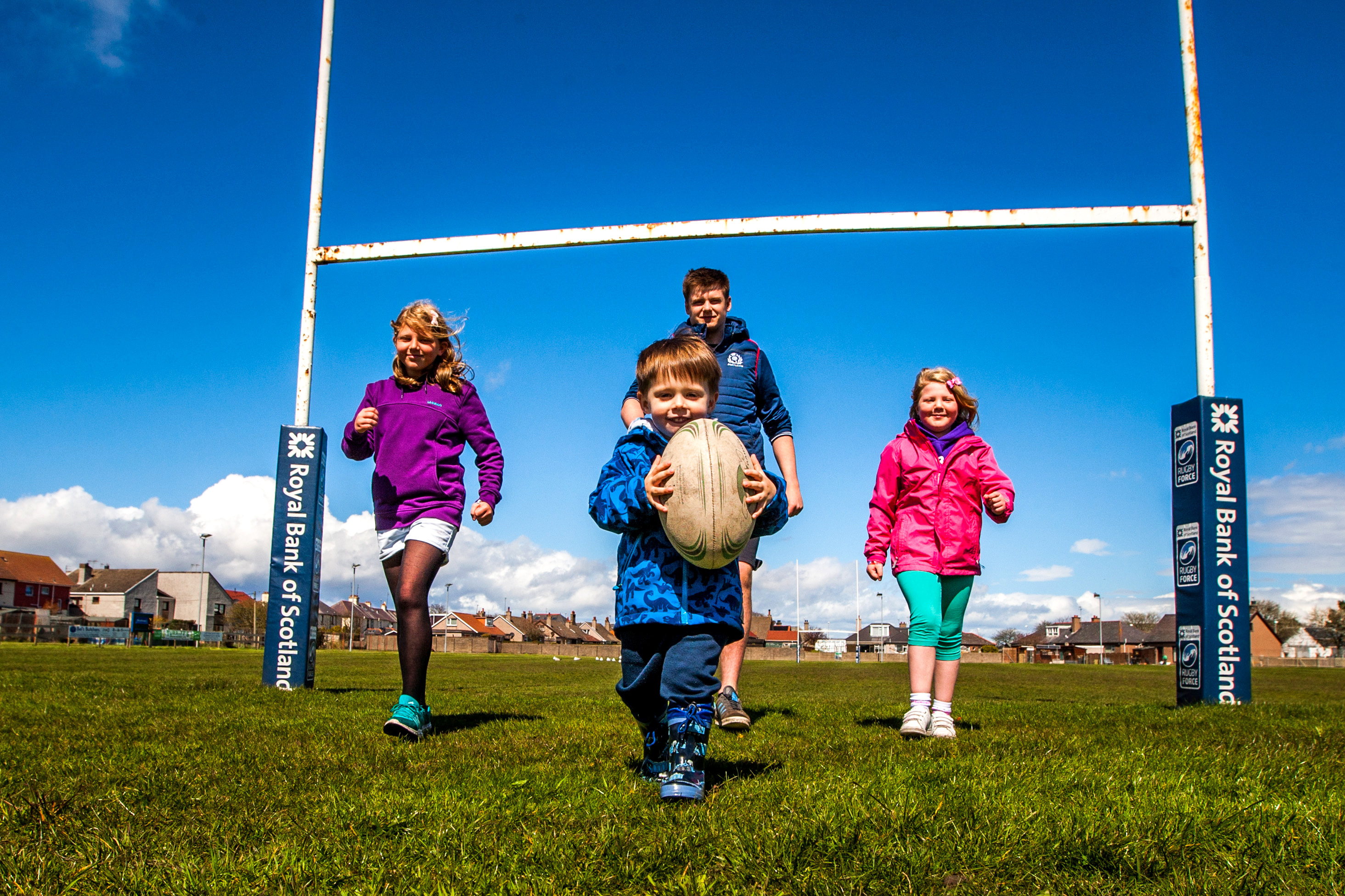 Three-year-old Caleb MacPherson alongside Aimee Webster and her sister Tracey with Montrose Rugby Club community coach Thomas Lindsay.