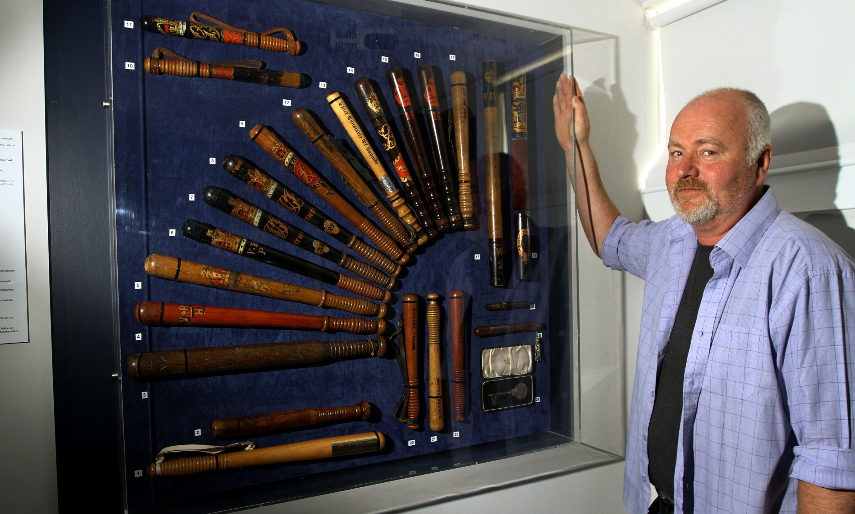 Retired Inspector Hamish Gray, beside a collection of police truncheons at Tayside Police Museum.