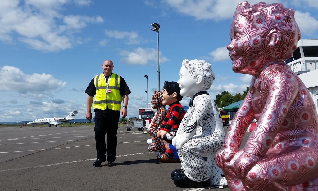 Crew manager Scott Raynor walks past an Oor Wullie guard of honour awaiting the first flight from Amsterdam.