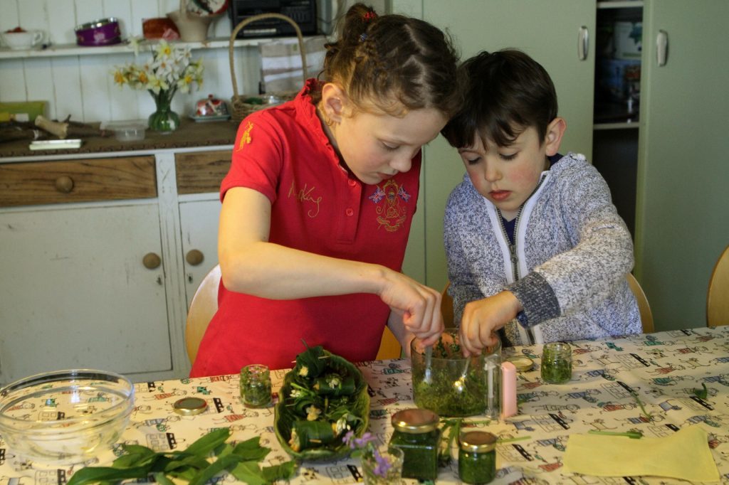 Ellie and Robbie Towns putting pesto into jars.