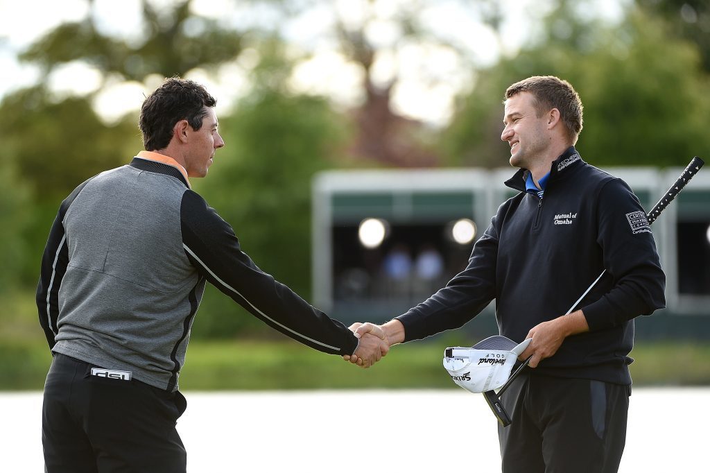 Rory McIlroy shakes hands with Russell Knox of Scotland.
