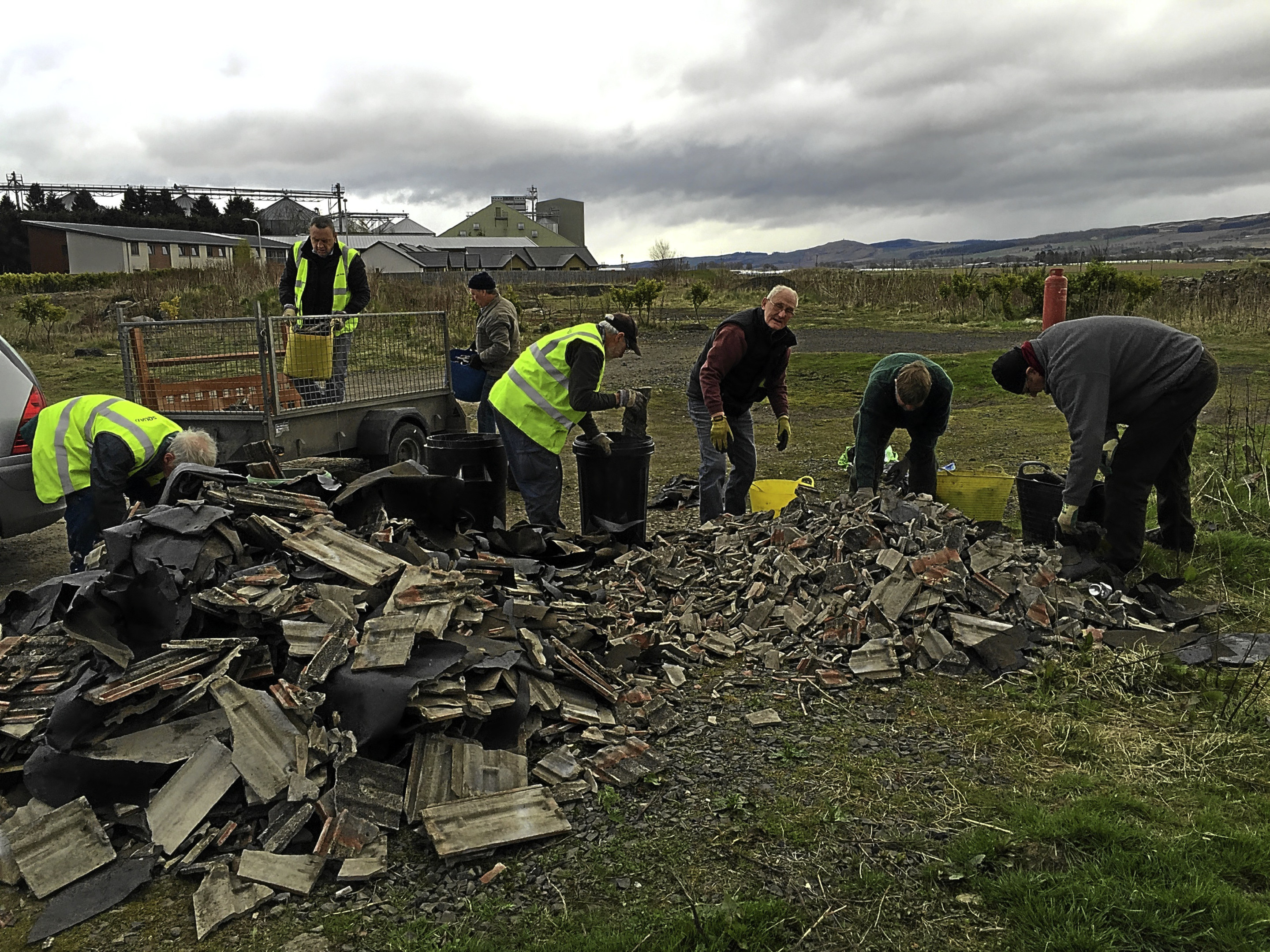 The MAD (Make A Difference) squad cleaning up the  fly tipping of roofing tiles at waste ground in Coupar Angus.