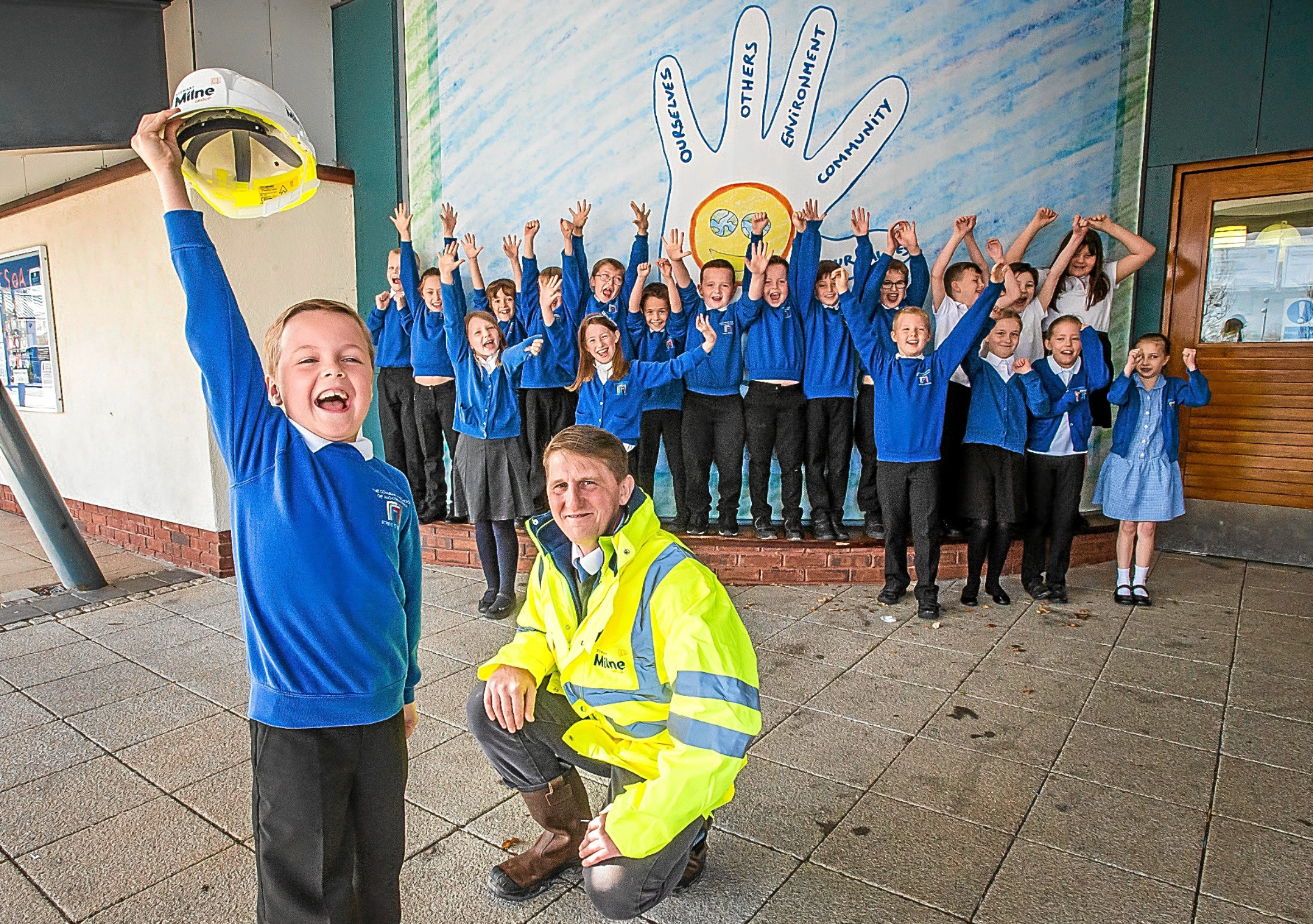 Primary four pupil Lucas Plowman with his classmates celebrating in front of his winning poster.