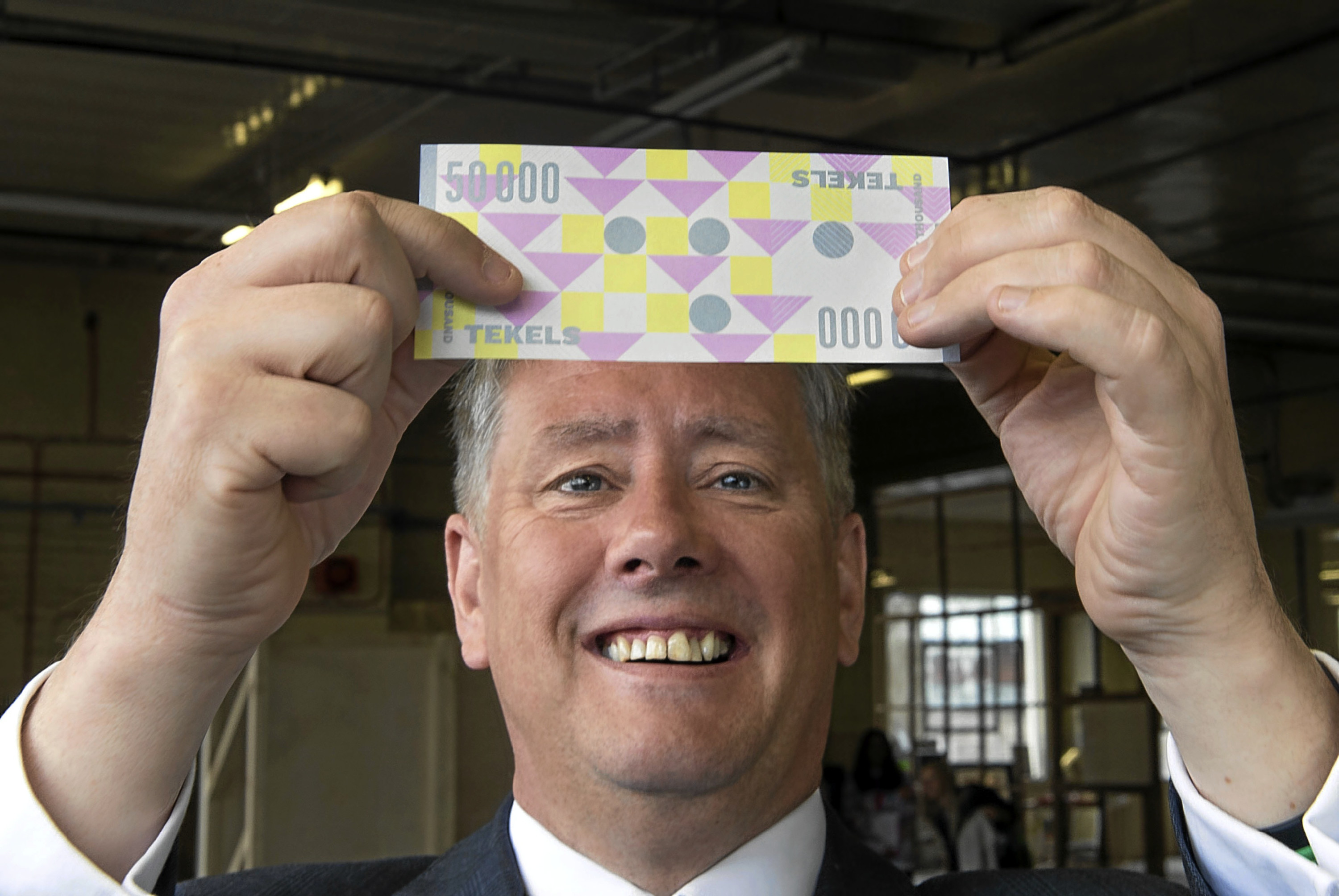 Economy minister Keith Brown with a "Tekel" banknote.