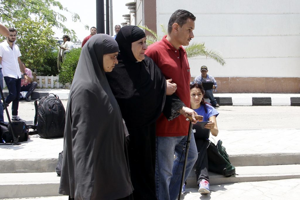 Relatives of passengers on an EgyptAir flight that crashed early Thursday walk past journalists at Cairo International Airport, Egypt, Thursday, May 19, 2016.  The EgyptAir jetliner bound from Paris to Cairo with 66 people aboard crashed in the Mediterranean Sea early Thursday after swerving wildly in flight, authorities said, and Egypt said it may have been a terrorist attack. (AP Photo/Ahmed Abd el Fattah)