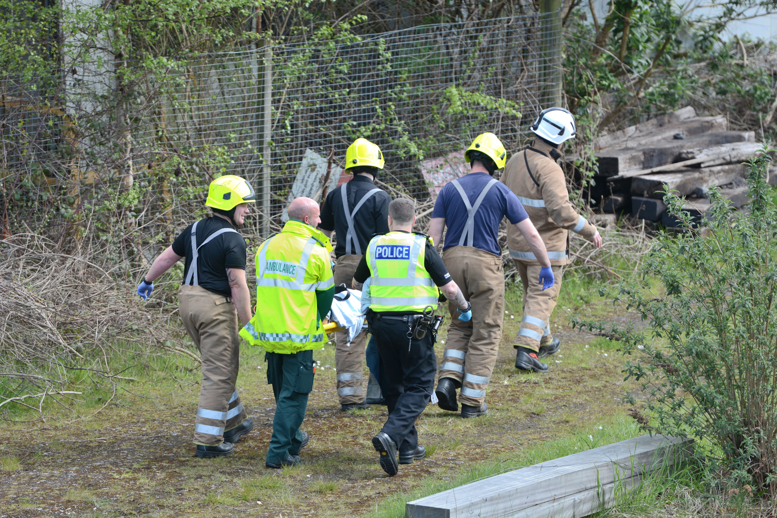 The injured man is led away after accident at Perth railway line.