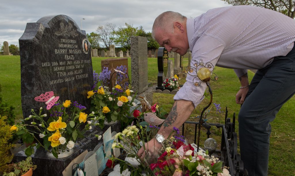 Alan McLean tends the grave of his son Barry McLean who died after a knife attack on May 28, 2011.