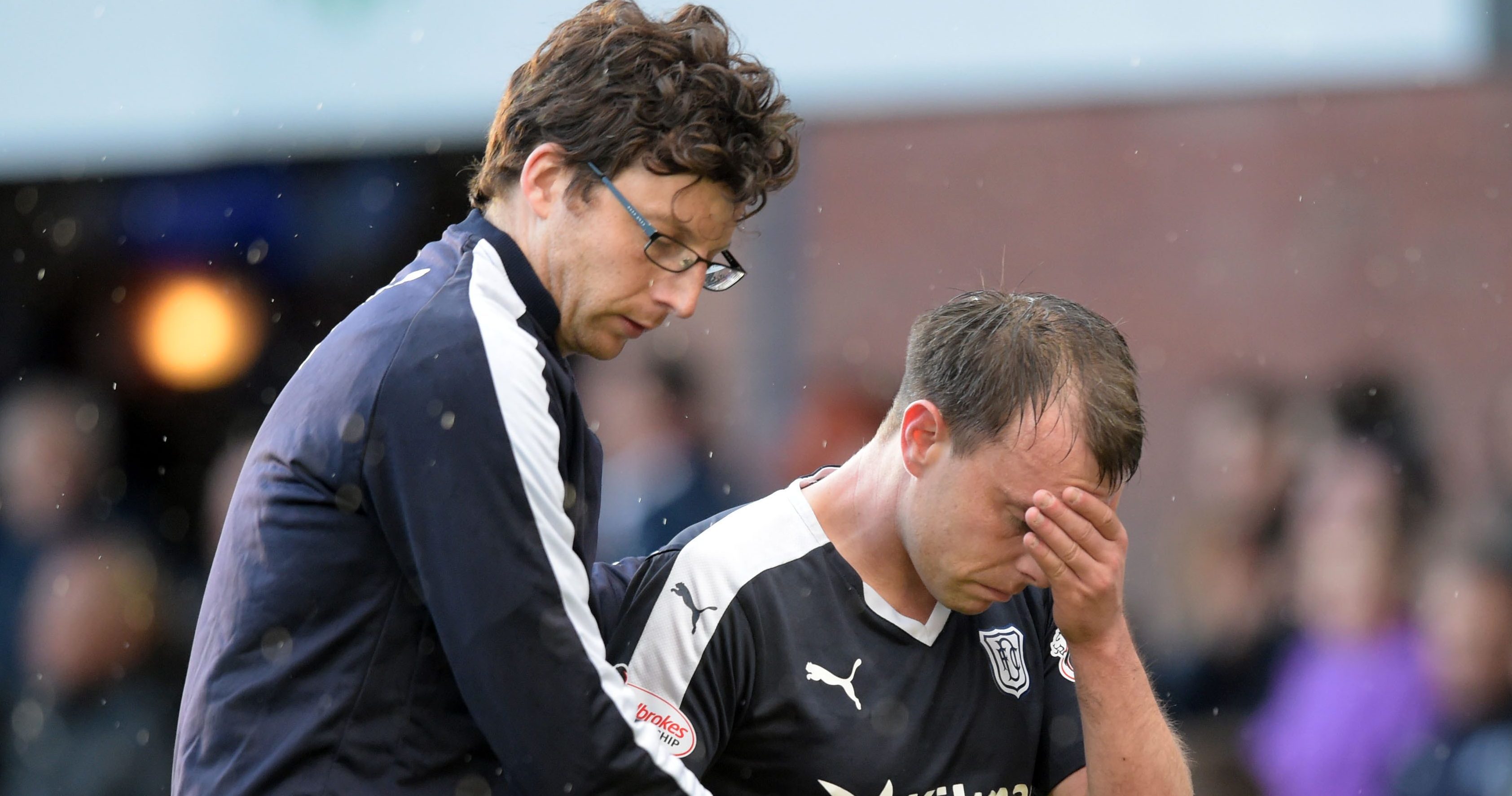 Paul McGowan is helped off during the derby.