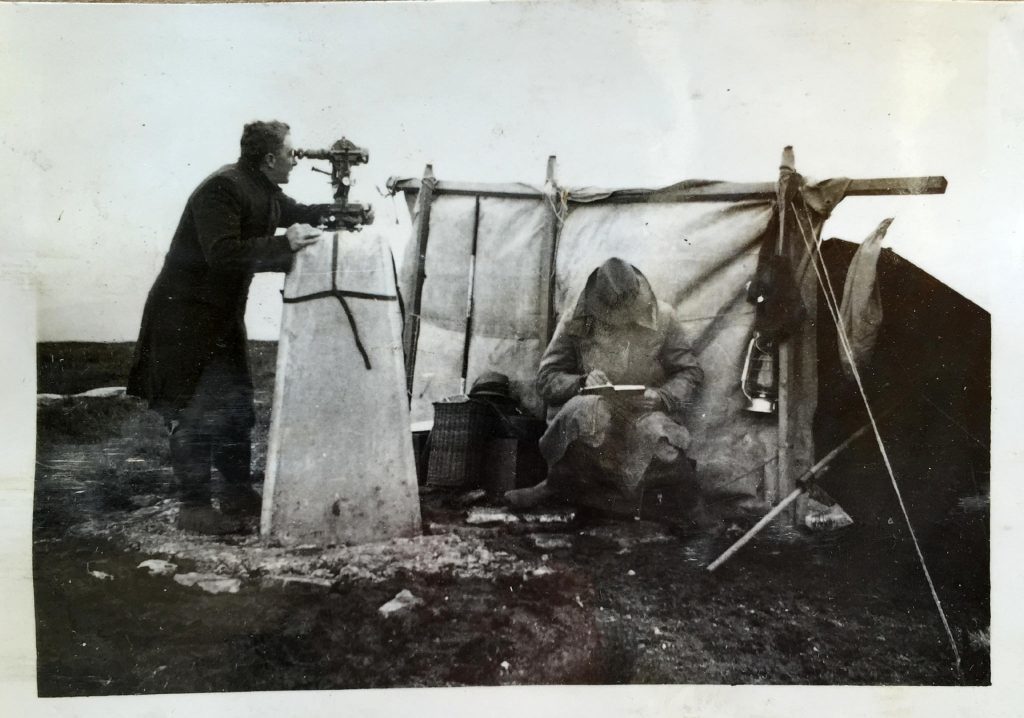 Surveying from a trig pillar in the 1930s.