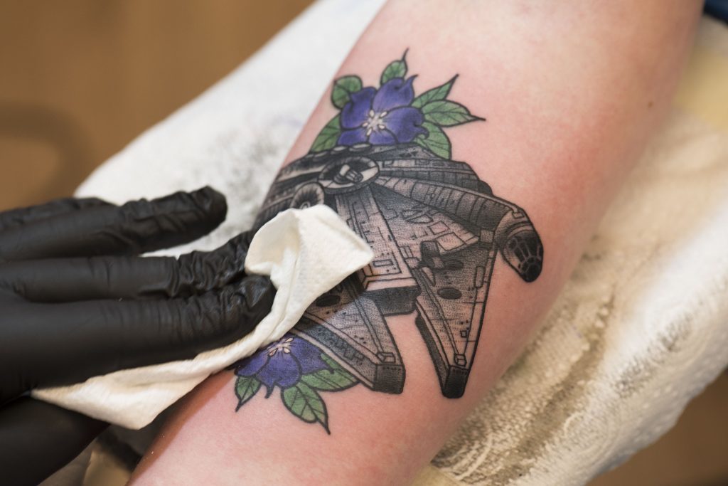 The finishing touches are added to a Millennium Falcon tattoo
