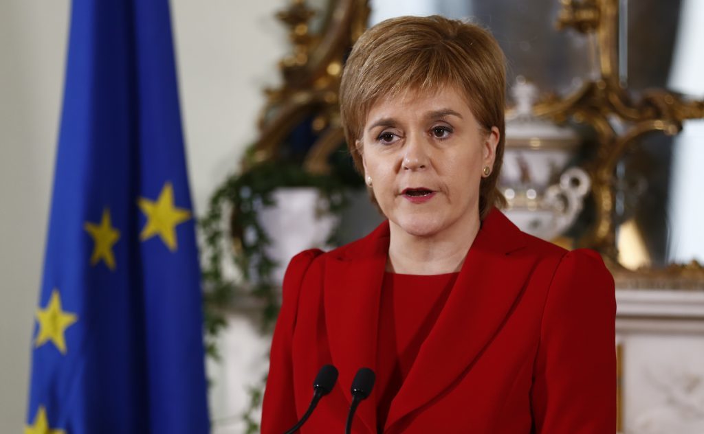Nicola Sturgeon announces her reaction to Brexit, flanked by EU and Saltire flags.