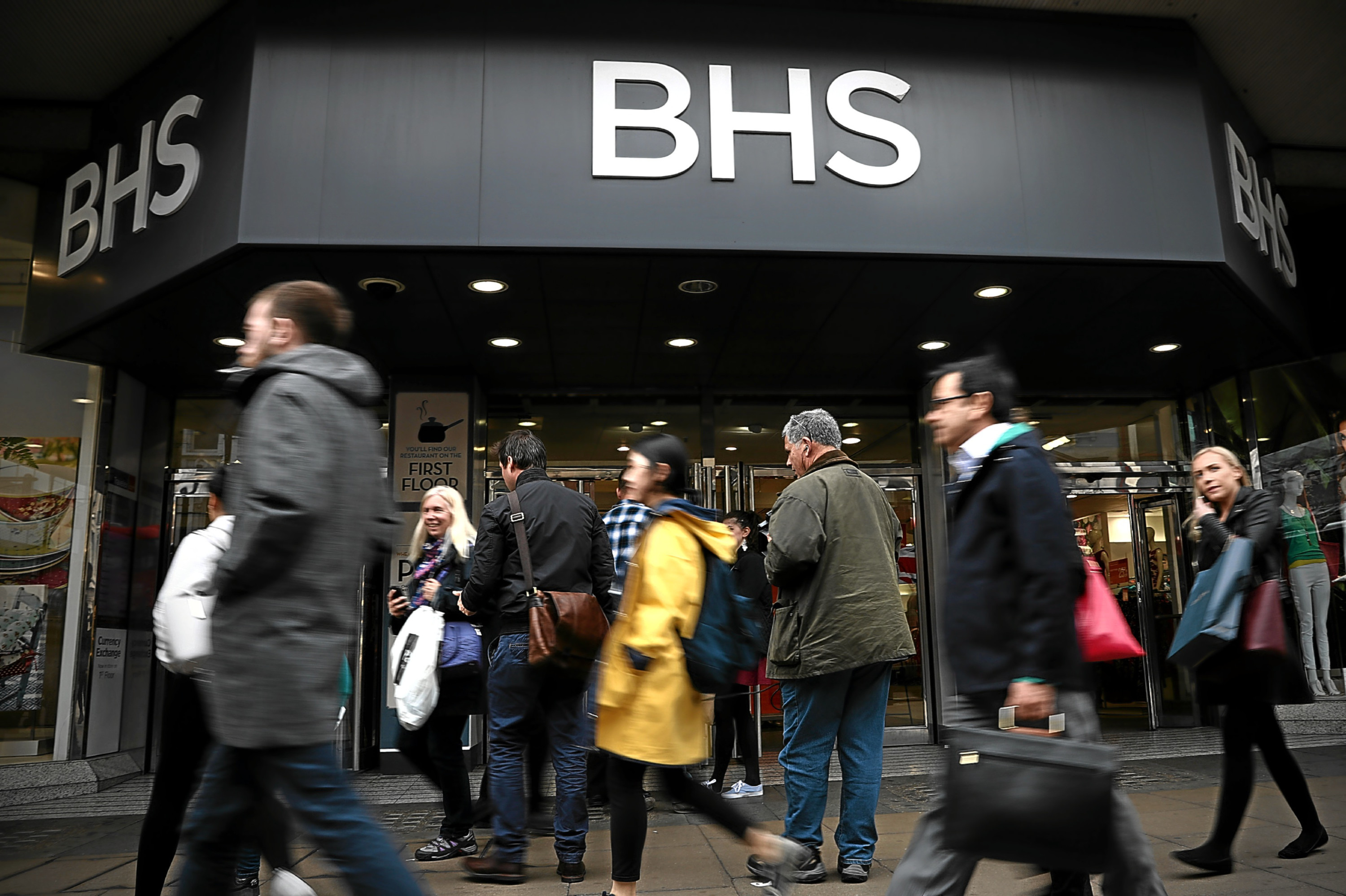 People walk past a branch of British Home Stores