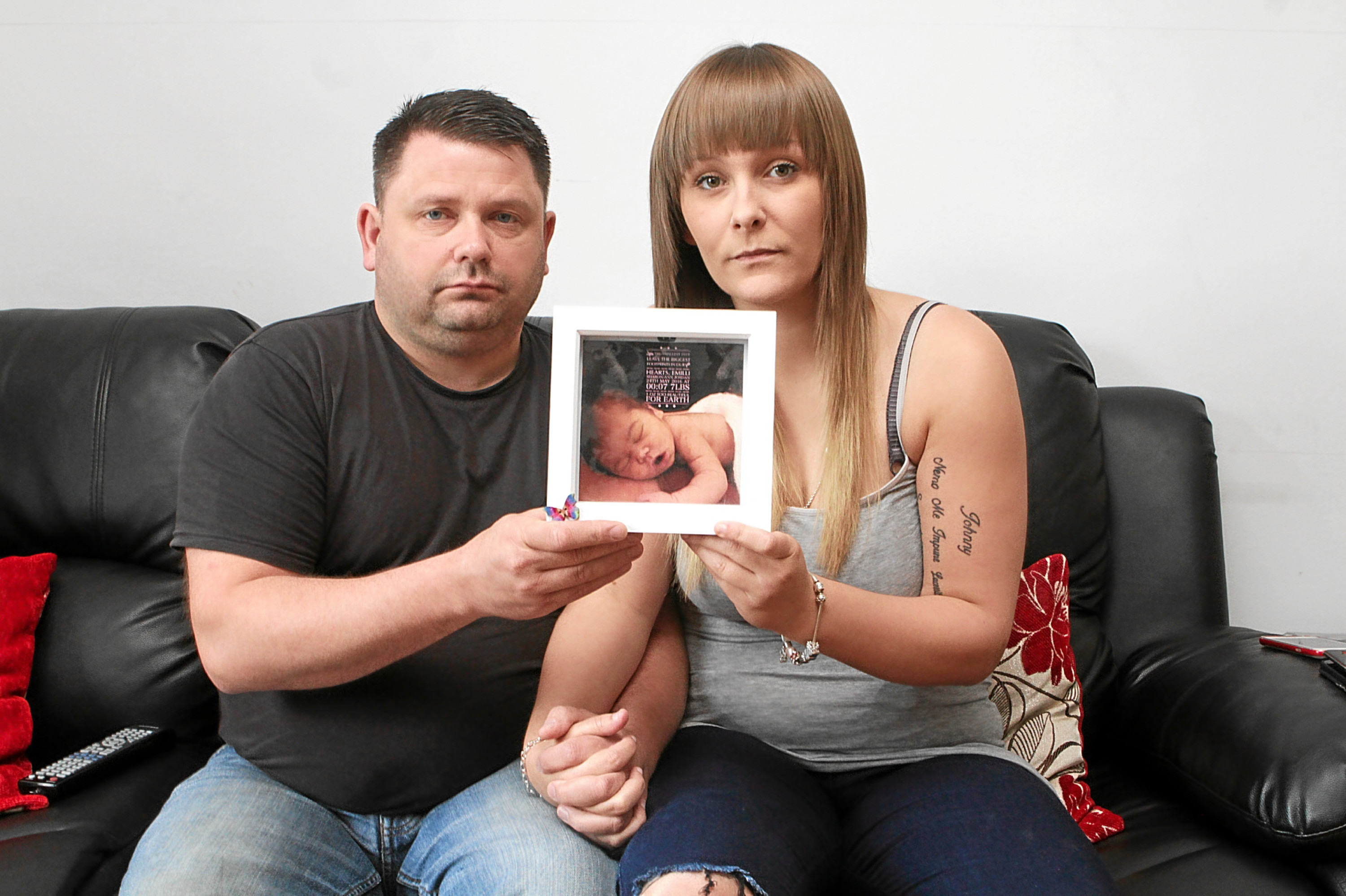 Parents Michael Jordan and Chloe Moore with a photo of baby Emilli.