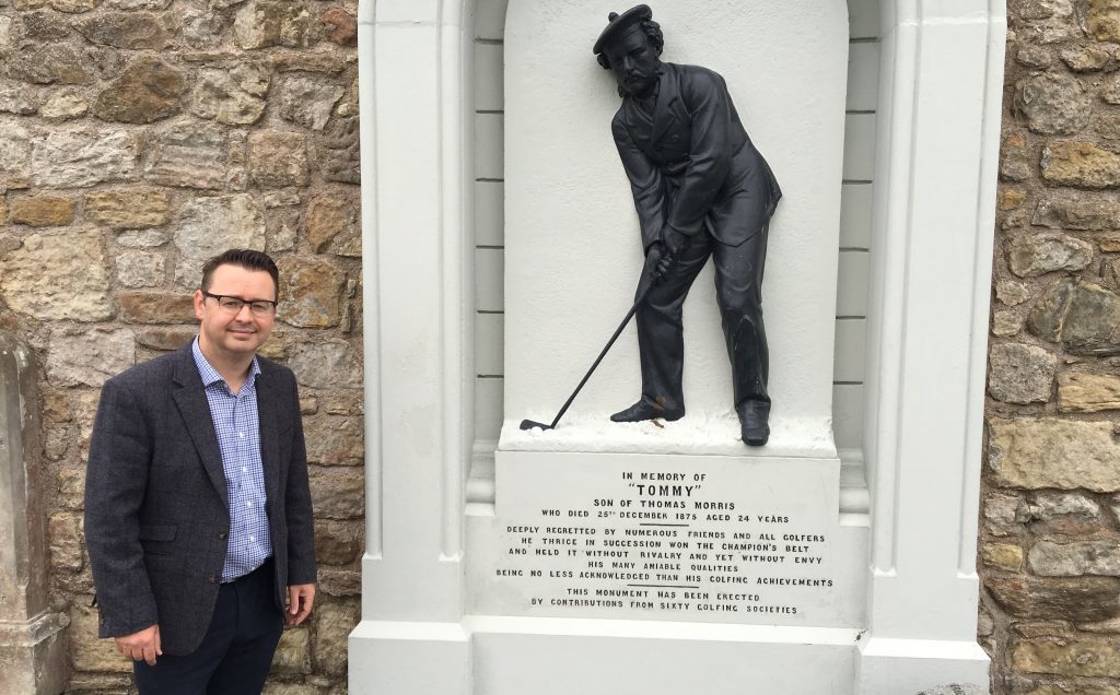 St Andrews-based author Roger McStravick next to the Tommy Morris memorial in the grounds of St Andrews Cathedral