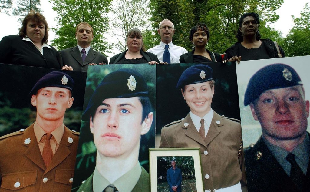 Yvonne Collinson (formerly Gray), Jim Collinson, Diane Gray, Geoff Gray, Deveen Clarke and Glasme Davis hold picture boards of soldiers who died while serving at Deepcut Barracks.