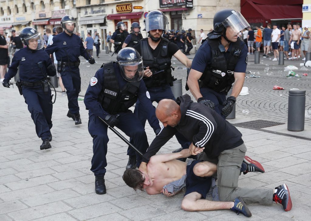 A man is apprehended by French police in downtown Marseille, France, Friday, June 10, 2016. Some minor scuffles on Friday and the brief clashes late Thursday revived bitter memories of days of bloody fighting in this Mediterranean port city between England hooligans, Tunisia fans and locals of North African origin during the World Cup in 1998, and raised fears of more violence ahead of Saturday's European Championship match between England and Russia at the Stade Velodrome. (AP Photo/Darko Bandic)