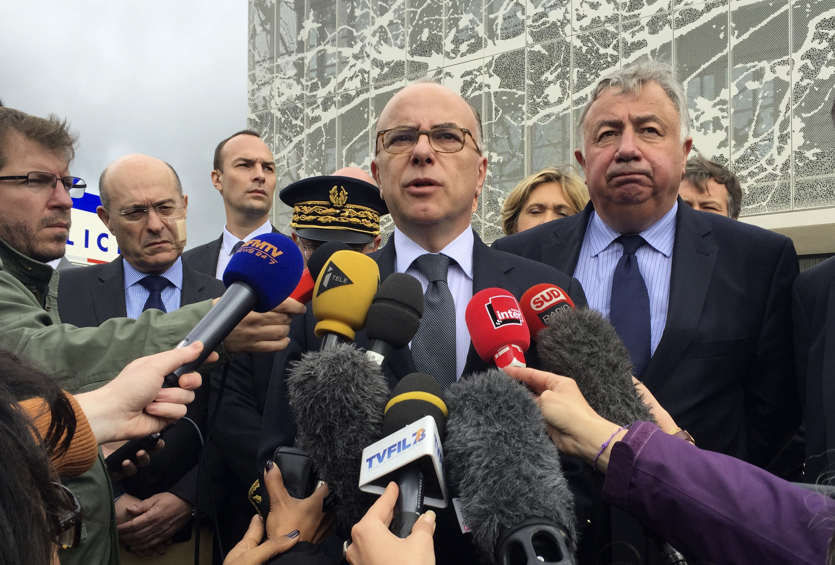 French Interior Minister Bernard Cazeneuve answers reporters after visiting the police station in Les Mureaux, west of Paris.