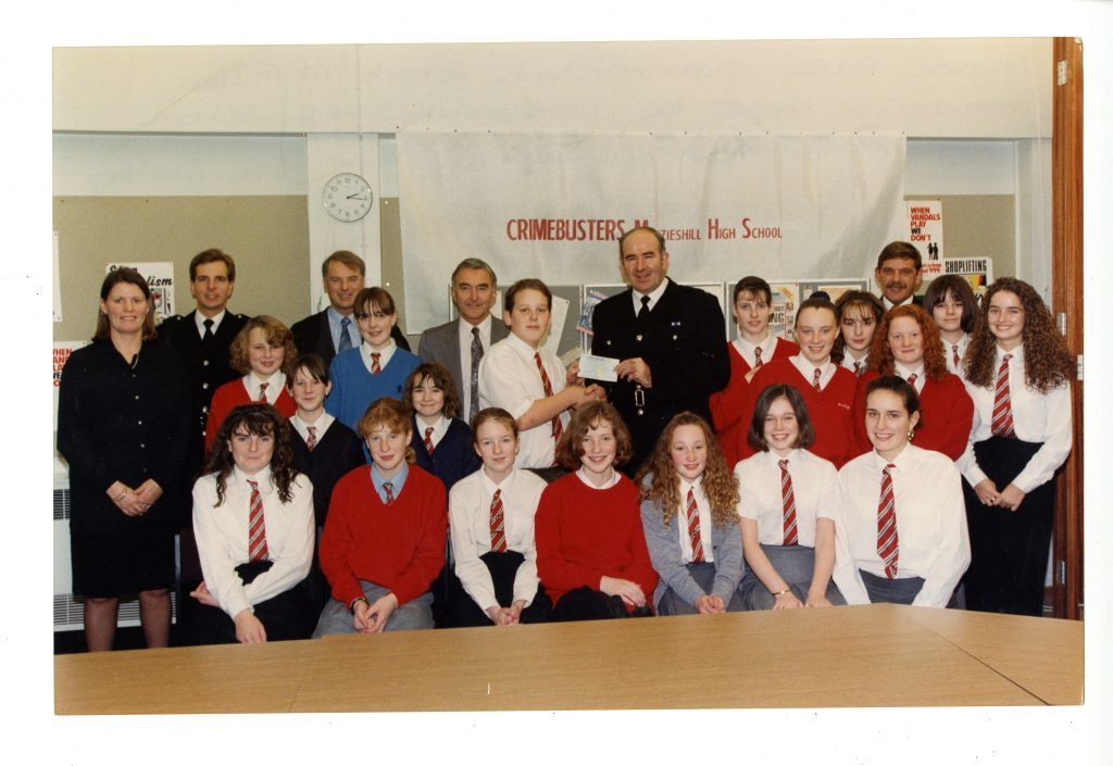 Tayside Police Superintendent Robert McMillan presenting a cheque to Menzieshill High School's youth crime prevention panel in 1992.