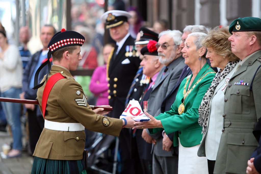 Courier News - ArmedForcesDay - FlagRaising - Forfar - Angus. Armed Forces Day. Town and County Hall. HM Lord Lieutenant, the Provost of Angus and past, present and future servicemen and women will muster behind the Town Hall on the north side and march, in order, a short distance to the south side at The Cross. The march will be coordinated by members of The Royal British Legion (Scotland) Forfar Branch and marching with Standard Bearers and Queens Colours following a lone Piper.  Once in position and at 10.30 the Bugler will sound at which point the commissioned AFD flag will be raised. Picture shows; S/Sgt Cameron Keith presenting the Armed Forces day flag to Provost of Angus Helen Oswald, Monday 20 June 2016.