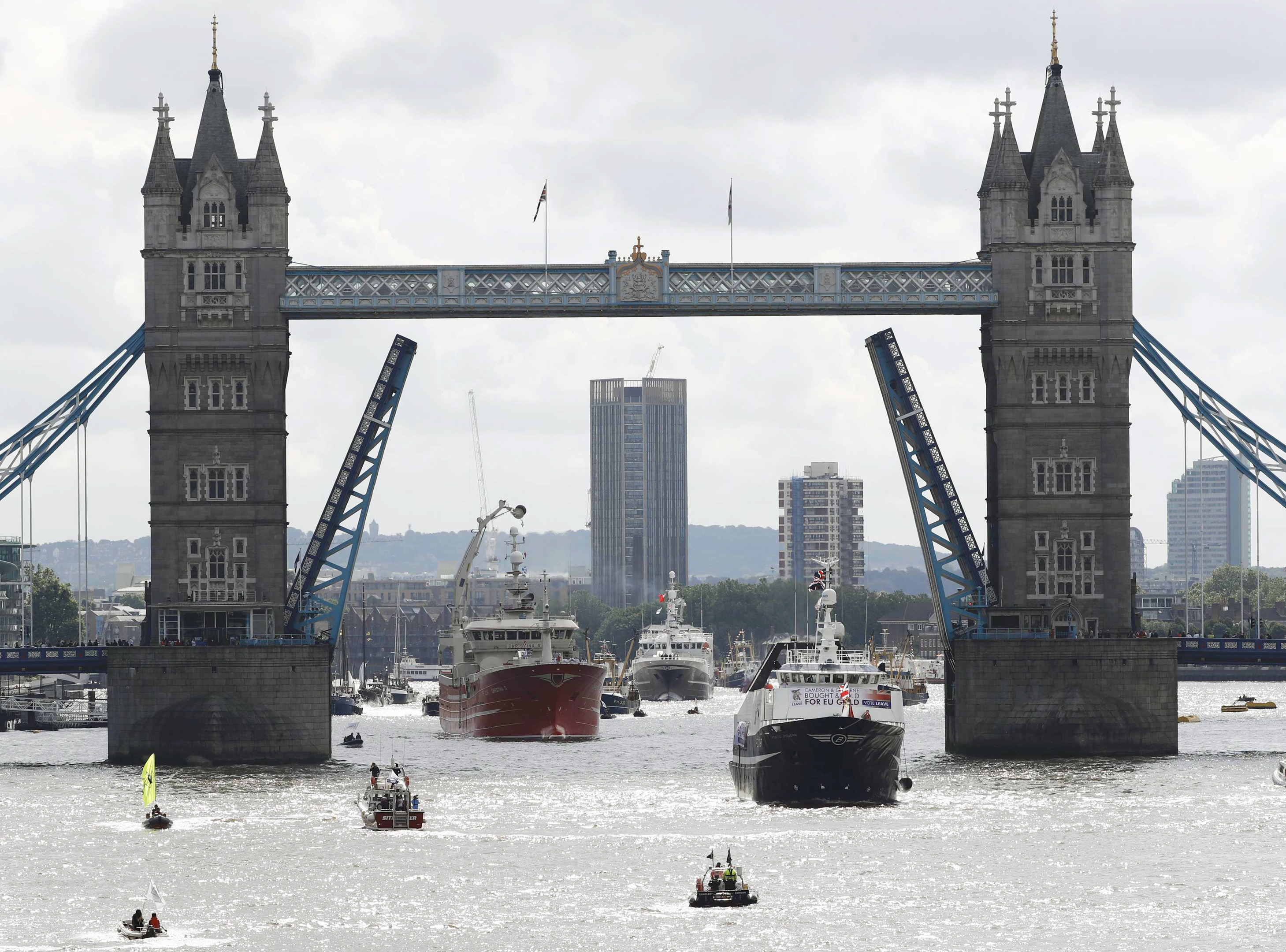A pro-Remain inflatable dinghy sails alongside a Fishing for Leave pro-Brexit "flotilla" making its way under Tower Bridge.