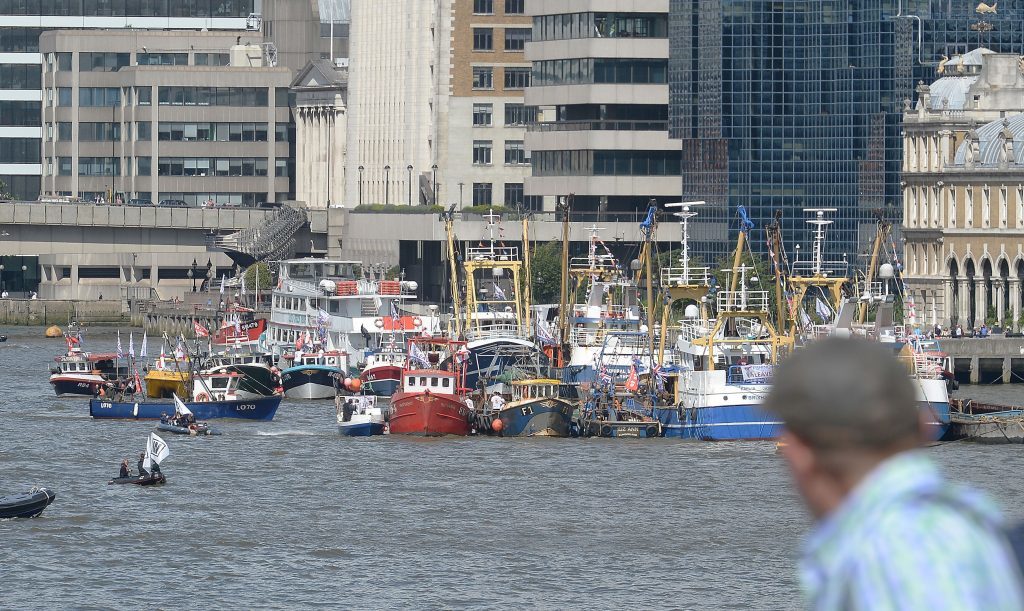 A man watches as a Fishing for Leave pro-Brexit "flotilla" and pro-EU counter demonstration boats make their way along the River Thames in London.