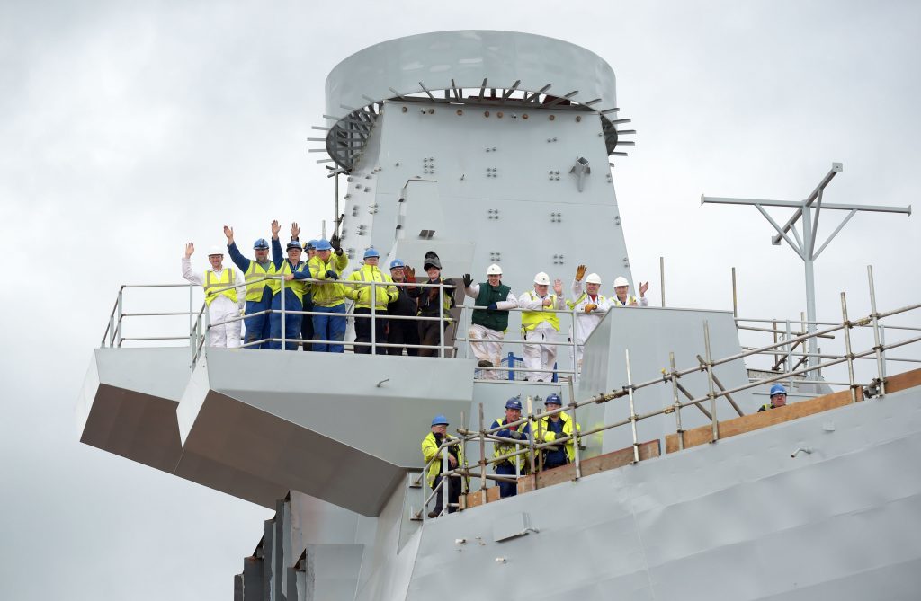 Workers wave during the tour by the Prince of Wales, known as the Duke of Rothesay when in Scotland,  of the aircraft carrier HMS Prince of Wales at Rosyth Dockyard, Rosyth. PRESS ASSOCIATION Photo. Picture date: Tuesday June 21, 2016. PRESS ASSOCIATION Photo. Picture date: Tuesday June 21, 2016. Photo credit should read: Jane Barlow/PA Wire.