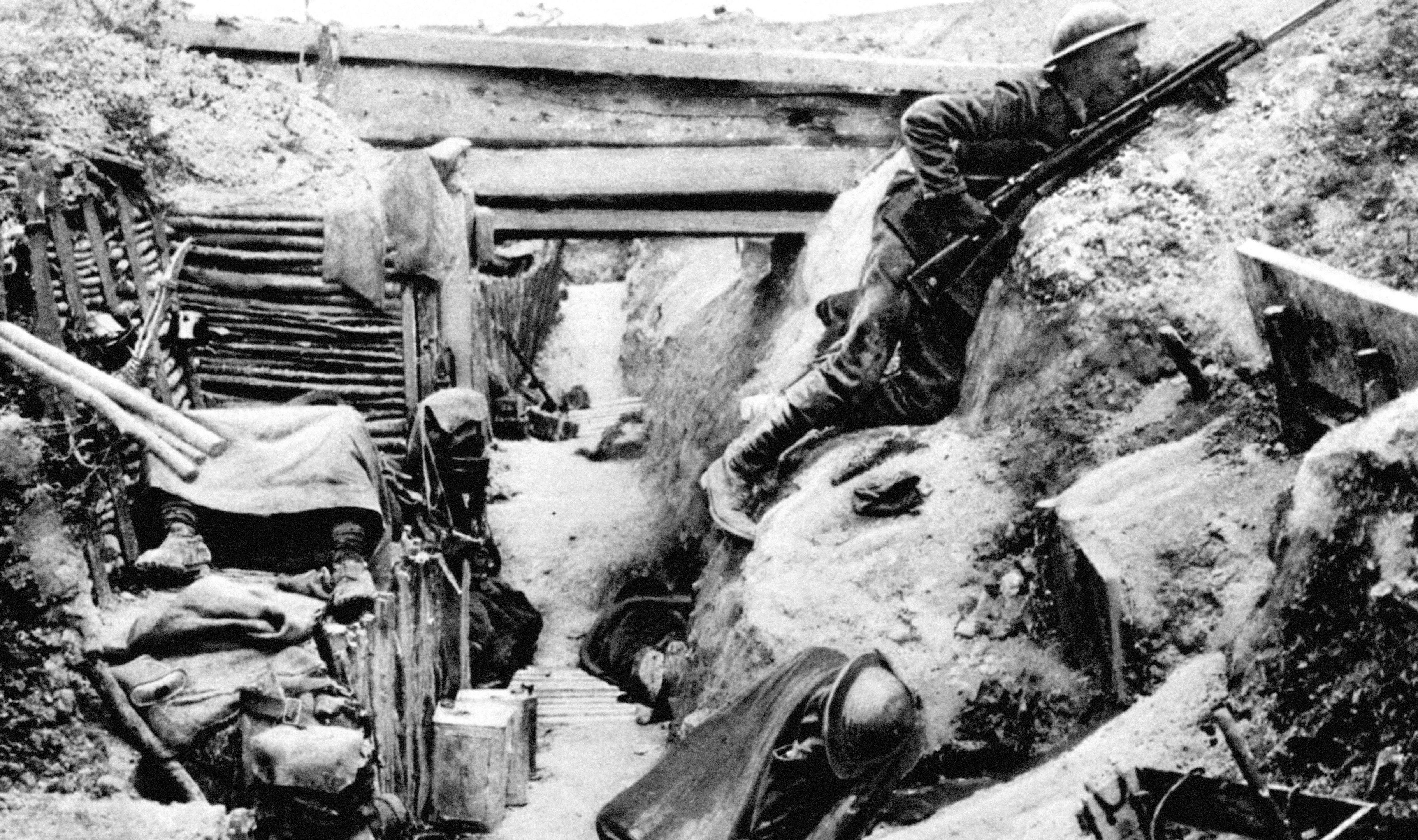 A British Grenadier Guardsman keeps watch on 'No-Man's land' as his comrades sleep in a captured German trench at Ovillers, near Albert, during the Battle of the Somme in 1916.